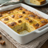 Golden brown pancake casserole with sausage in a white ceramic 9x13 baking dish