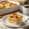 Golden brown pancake casserole with sausage in a white ceramic 9x13 baking dish
